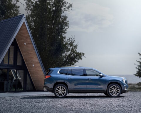 Wide angle side profile of the 2024 GMC Acadia Denali.