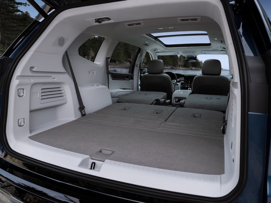 View of collapsed third and second row seats and cargo space in the 2024 GMC Acadia Denali.